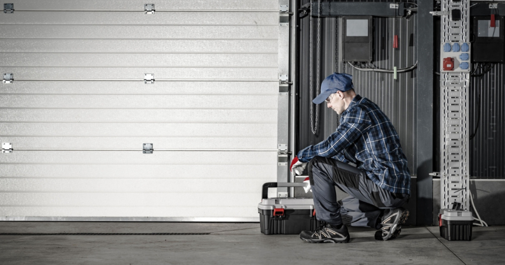 Technician repairing a large garage door.