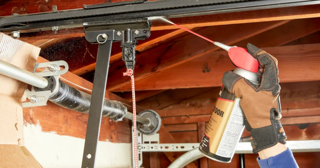 Applying lubricant to a garage door track.