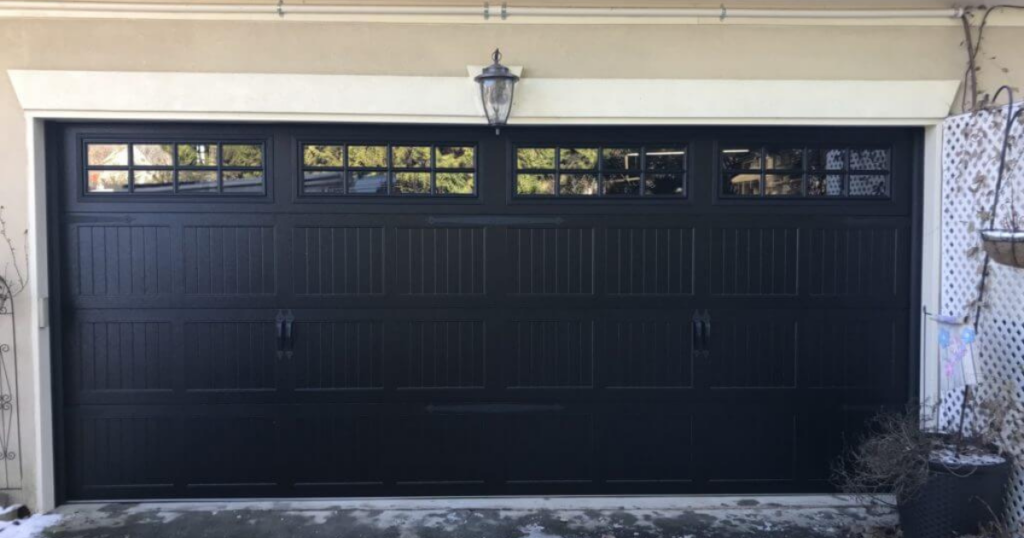 Black paneled garage door with top windows.